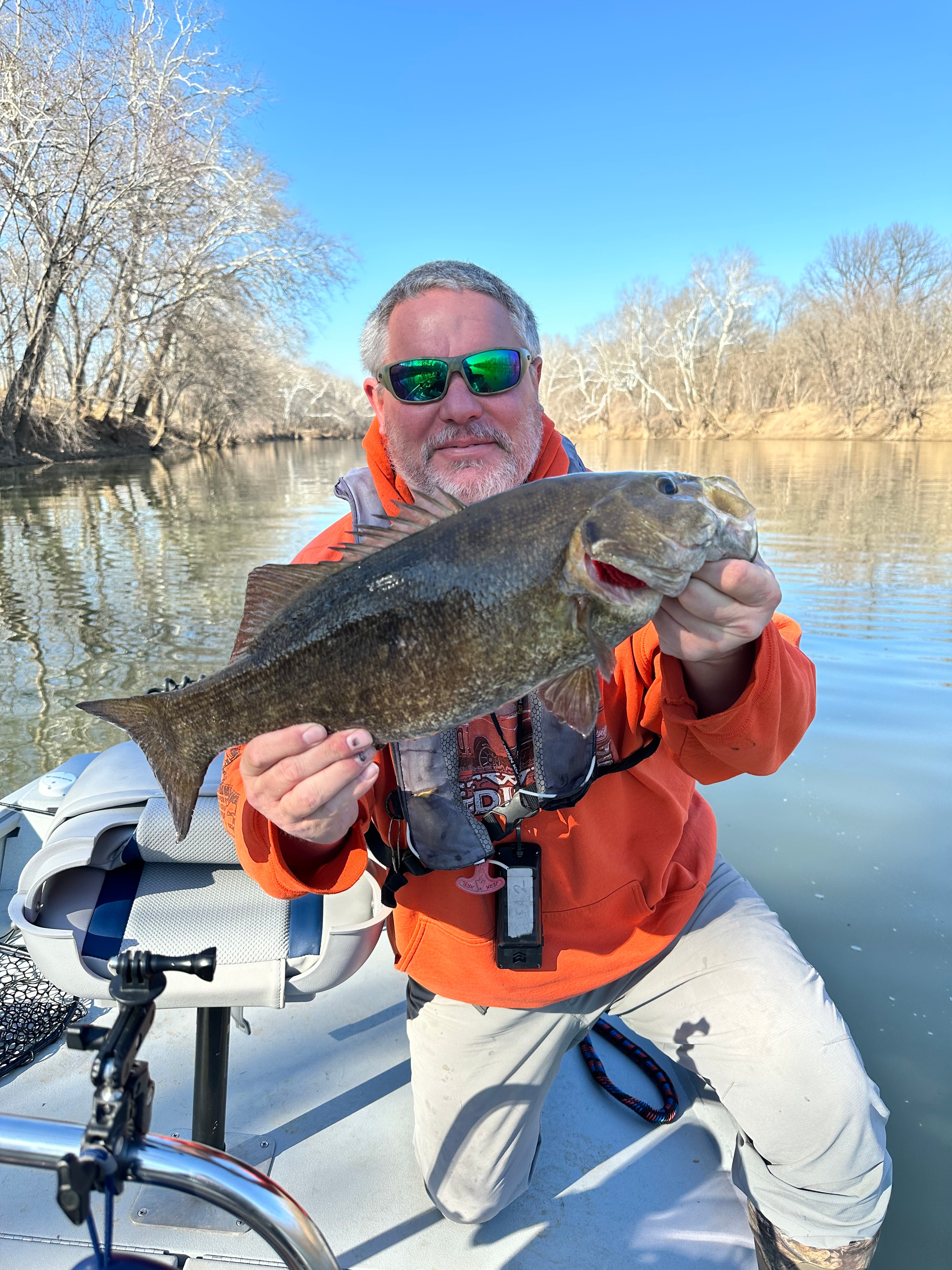 Jeff Greene holding a trophy smallmouth bass on the boat